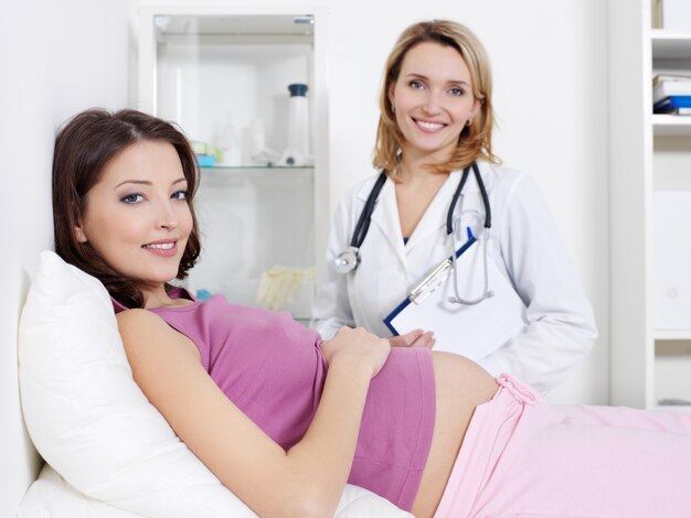 Szczęśliwa młoda kobieta w ciąży i jej lekarz w szpitalu