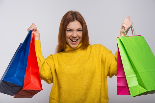Szczęśliwa młoda kobieta z kolorowymi torba na zakupy