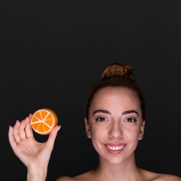 Bezpłatne zdjęcie szczęśliwa młoda kobieta z produktu do pielęgnacji skóry
