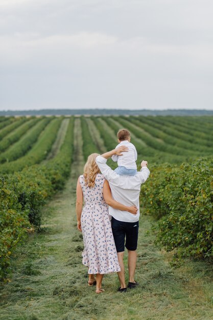 Szczęśliwa młoda rodzina tata, mama i synek wyglądają na szczęśliwych w parku