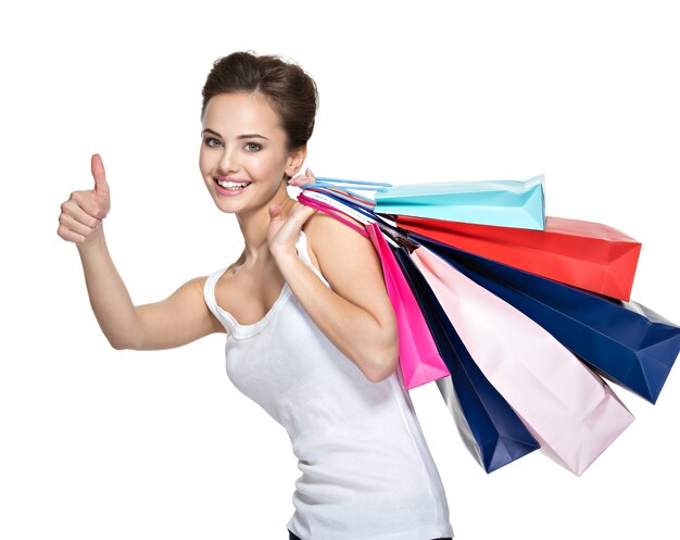 Szczęśliwa młoda uśmiechnięta kobieta z torby na zakupy po zakupach
