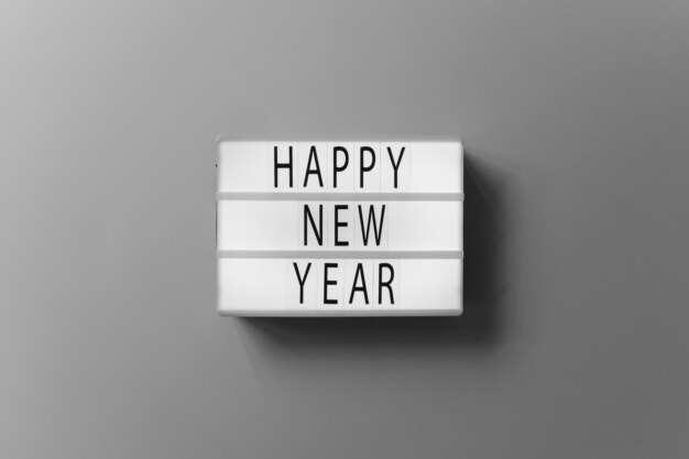 Szczęśliwa nowy rok inskrypcja na białej desce na stole