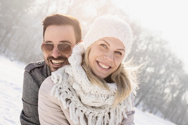 Szczęśliwa para ciesząca się pięknym śniegiem uchwyconym w zimny i śnieżny dzień