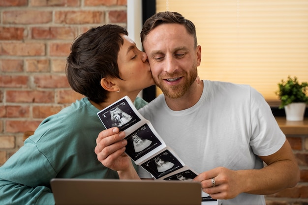 Bezpłatne zdjęcie szczęśliwa para ogłaszająca ciążę przez wideorozmowę