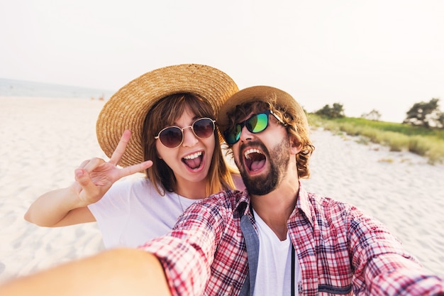 Szczęśliwa Podróżująca Para Zakochanych, Biorąc Selfie Na Telefon Na Plaży