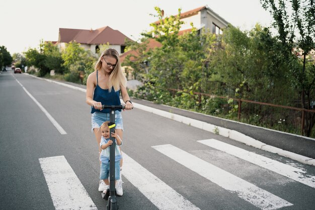 Szczęśliwa rodzina jedzie skuterem w okolicy na drodze.