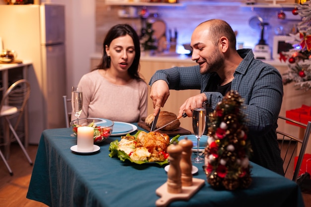 Szczęśliwa rodzina siedzi przy stole w świątecznej udekorowanej kuchni