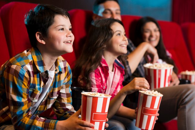 Szczęśliwa rodzina siedzi w kinie