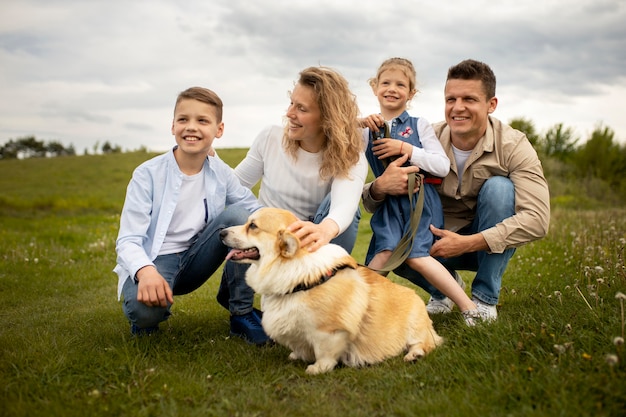Bezpłatne zdjęcie szczęśliwa rodzina z psem w pełnym ujęciu