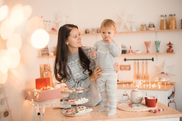 Szczęśliwa zabawna mama i dziecko mała dziewczynka bawi się w świątecznej udekorowanej kuchni