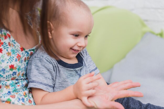 Szczęśliwe dziecko bawi się ze strony matki