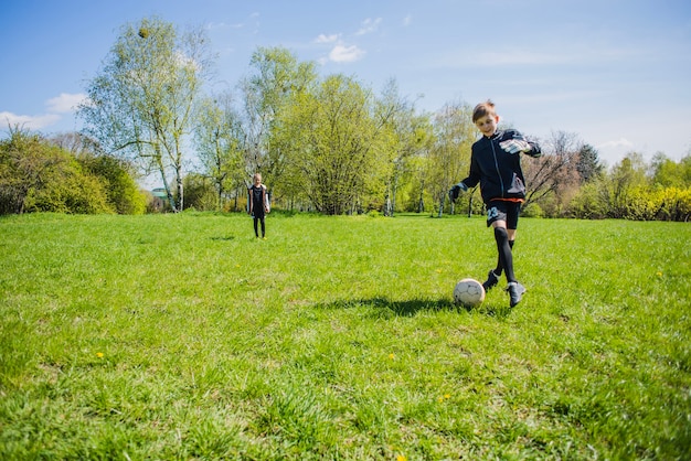 Szczęśliwe dziecko gra w piłkę nożną