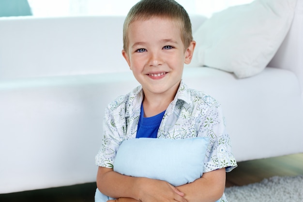 Bezpłatne zdjęcie szczęśliwe dziecko przytulając poduszkę