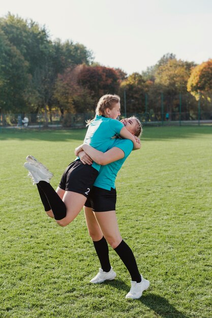 Szczęśliwe dziewczyny sportowe, obejmując się nawzajem