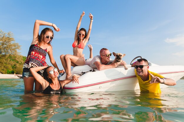 Szczęśliwe towarzystwo przyjaciół na letnich tropikalnych wakacjach w Tajlandii podróżujących statkiem po morzu, impreza na plaży, ludzie dobrze się bawiący, pozytywne emocje mężczyzn i kobiet