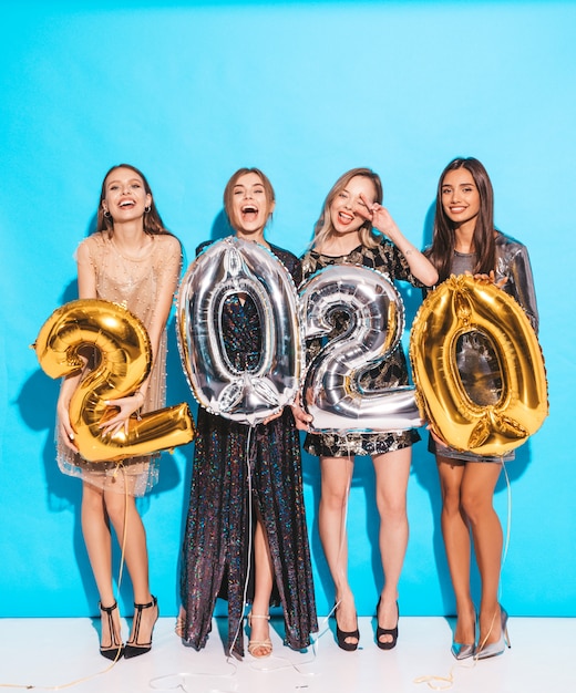 Bezpłatne zdjęcie szczęśliwe, wspaniałe dziewczyny w stylowych seksownych sukienkach posiadających balony złote i srebrne 2020