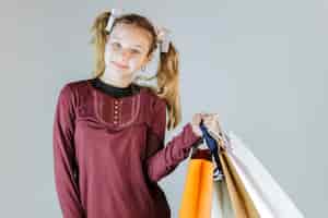 Bezpłatne zdjęcie szczęśliwi dziewczyny mienia torba na zakupy na popielatym tle