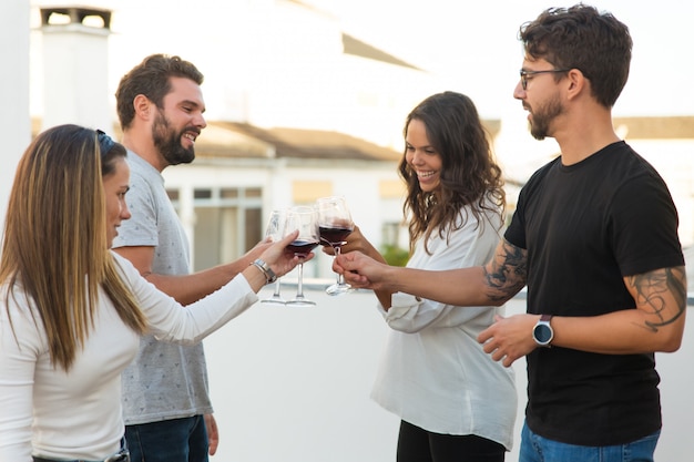 Szczęśliwi ludzie opiekający wino i świętujący wydarzenie
