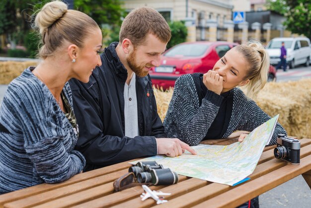 Szczęśliwi podróżnicy siedzący z mapą