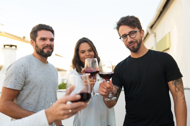 Szczęśliwi pozytywni ludzie opiekający wino
