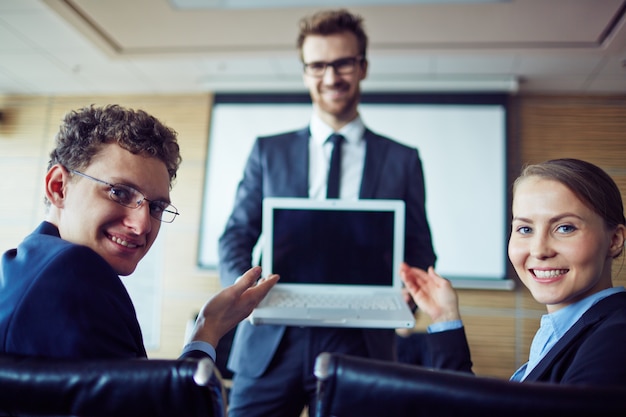 Bezpłatne zdjęcie szczęśliwi pracownicy posiadający laptopa