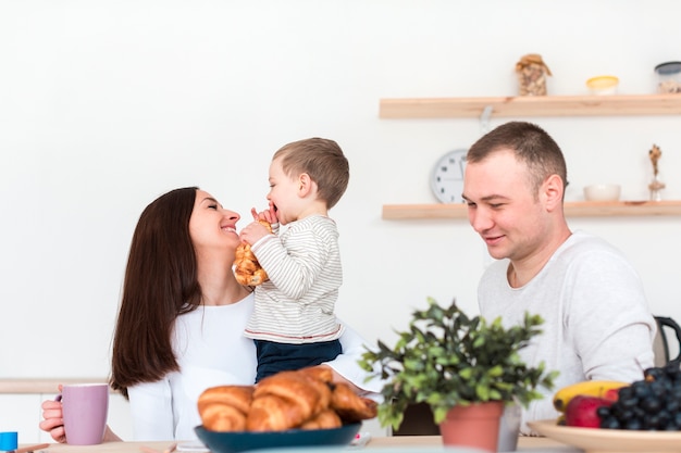 Szczęśliwi rodzice trzyma dziecka w kuchni