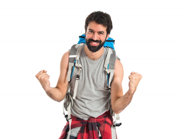 Szczęśliwy backpacker ponad pojedyncze białe tło