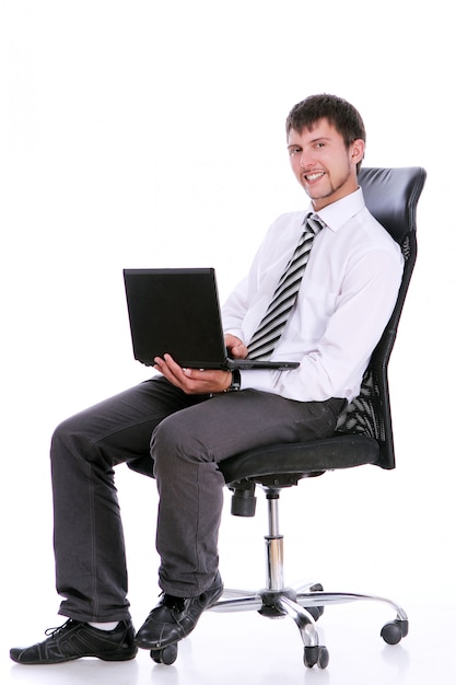 Szczęśliwy biznesmen na krześle z laptopem