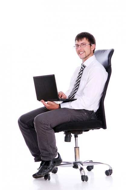 Szczęśliwy biznesmen na krześle z laptopem