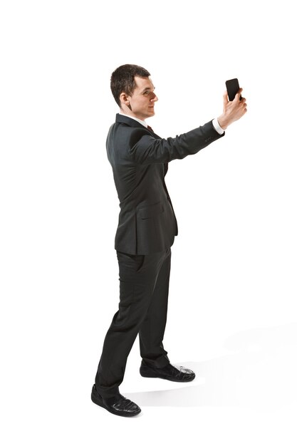 Szczęśliwy biznesmen rozmawia przez telefon samodzielnie na białym tle w studio fotografowania