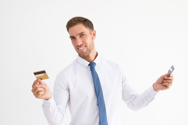 Szczęśliwy biznesowy mężczyzna trzyma dwa plastikowej karty
