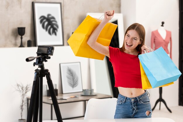 Szczęśliwy blogger trzyma torby na zakupy