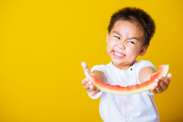 Szczęśliwy chłopiec azjatyckich dziecko uśmiech trzyma rżnięty arbuz świeży dla jedzenia