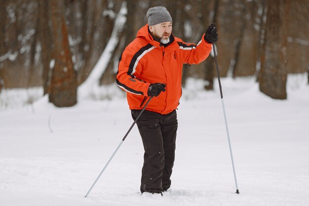 Szczęśliwy dojrzały mężczyzna w winter park. Senior aktywna trekking w lesie w czasie wolnym