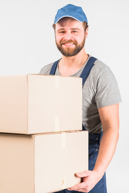 Szczęśliwy doręczeniowy mężczyzna trzyma dużych pudełka