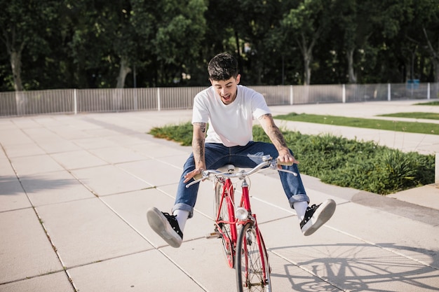 Szczęśliwy młody cyklista cieszy się przejażdżkę na jego bicyklu