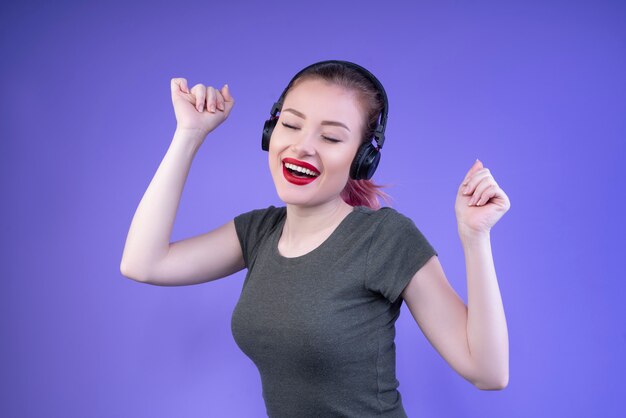 Szczęśliwy nastolatek cieszy się muzykę z zamkniętymi oczami i otwartym usta