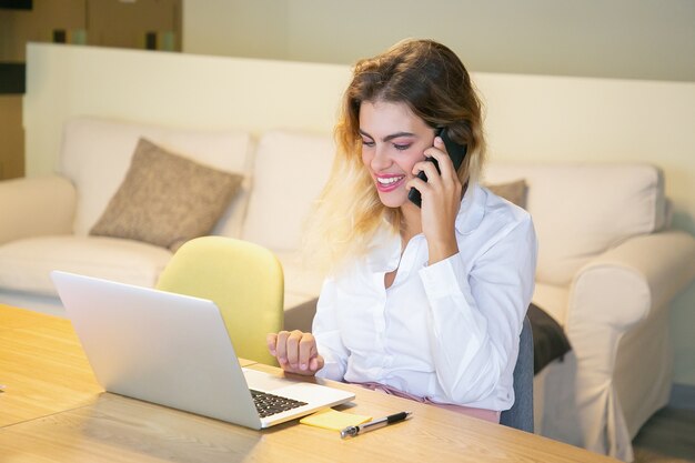 Szczęśliwy, odnoszący sukcesy menedżer omawiający projekt z klientem przez telefon