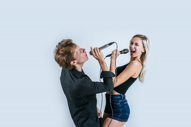 Bezpłatne zdjęcie szczęśliwy portret pary mienia mikrofon i śpiewa piosenkę