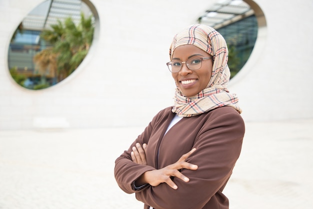 Szczęśliwy radosny Muzułmański bizneswoman pozuje outside