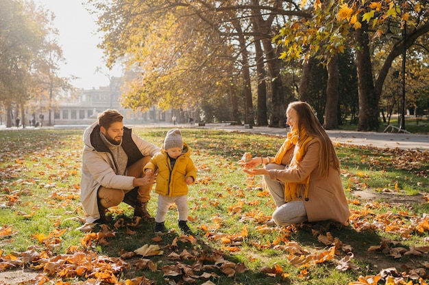 Szczęśliwy tata i mama bawi się z dzieckiem na świeżym powietrzu