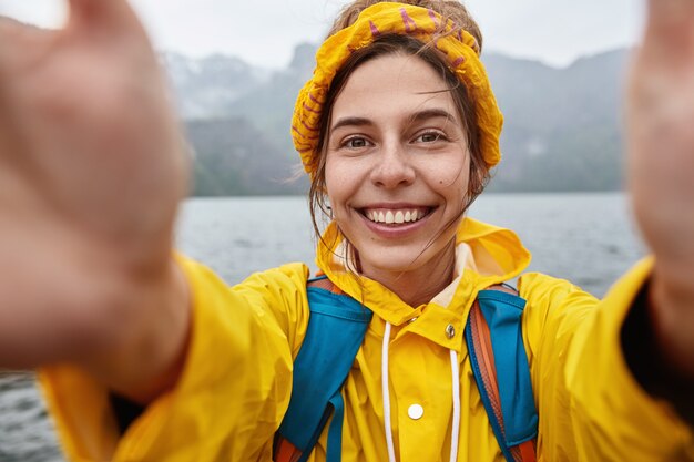 Szczęśliwy wędrowiec lubi wyprawy pełne przygód, robi selfie na tle majestatycznego górskiego krajobrazu