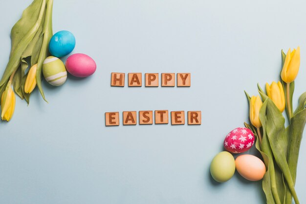 Szczęśliwy Wielkanocny writing wśród jajek i tulipanów