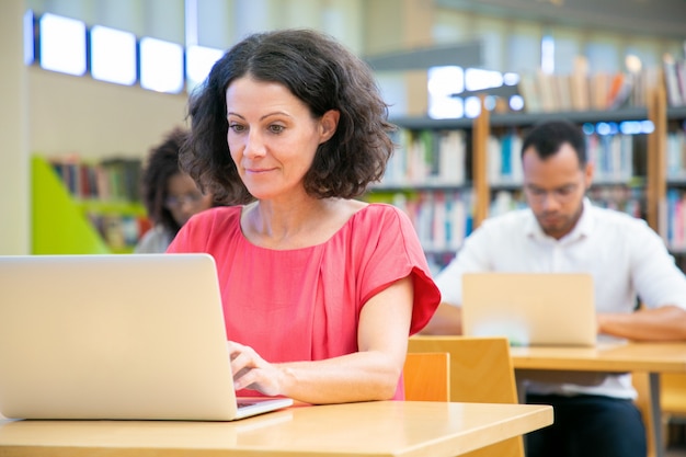 Szczęśliwy żeński dorosły uczeń przechodzi online test