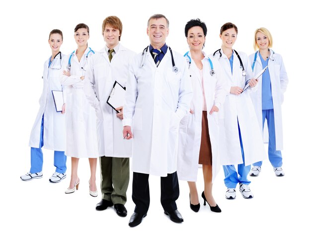 Szczęśliwy zespół odnoszących sukcesy lekarzy stojących razem w szpitalnych togach