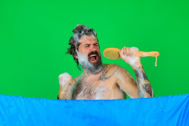 Szczotka do kąpieli mężczyzna ze szczotką do kąpieli śpiewający mężczyzna weź prysznic mężczyzna z pianką na głowie mycie ciała brodaty