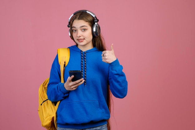 Szczupła młoda studentka z długimi włosami patrząca w kamerę