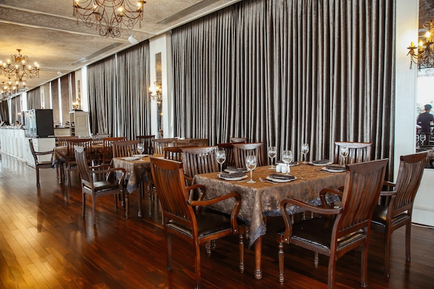 Szeroka sala restauracyjna z drewnianym stołem i krzesłami dla 6 osób