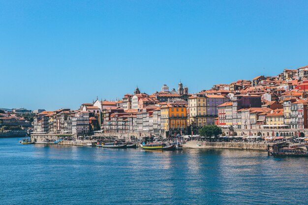Szeroki strzał łodzie na ciele wodni pobliscy domy i budynki w Porto, Portugalia