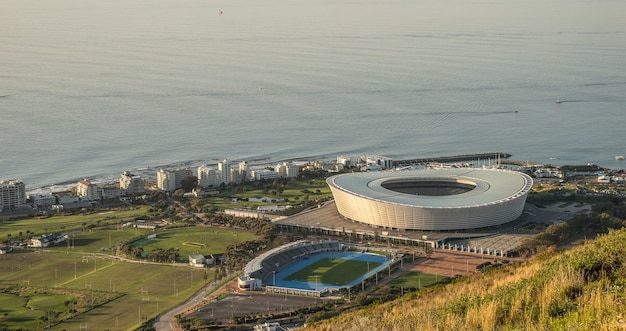 Szerokokątne ujęcie okrągłego stadionu i innych budynków wokół boiska nad oceanem